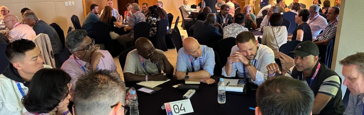 A group of people discussing issues related to fundraising in round tables in a room at the Lausanne Congress in Seoul.