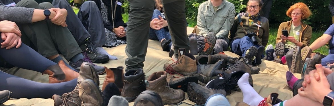 A circle of adults playing 'The Shoe' game