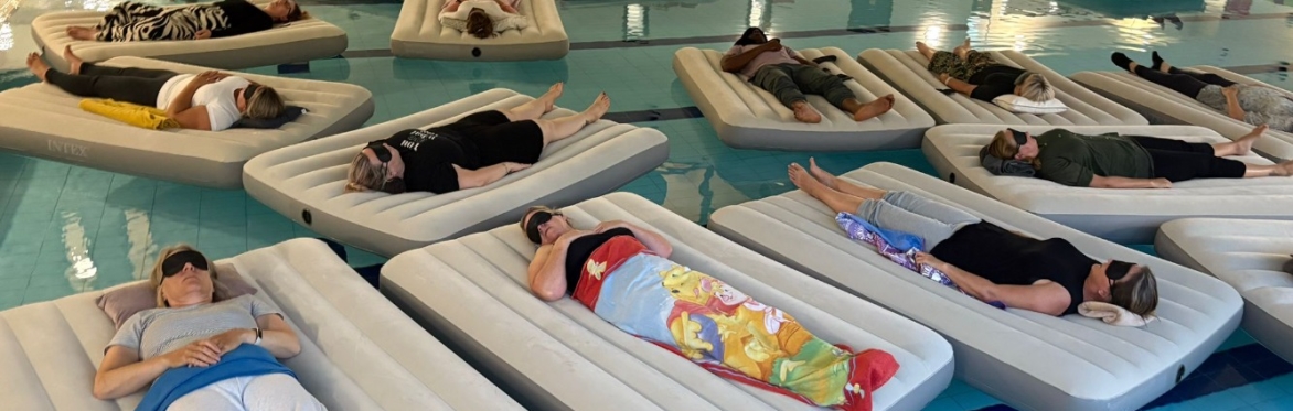 Customers laying on a comfy air mattress and floating in a swimming pool