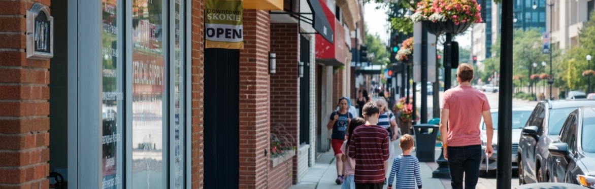 Pedestrians walk down a street in Downtown Skokie