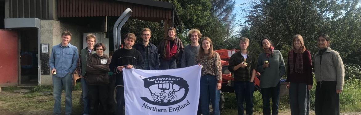 a group of FLAME members holding a landworkers alliance poster