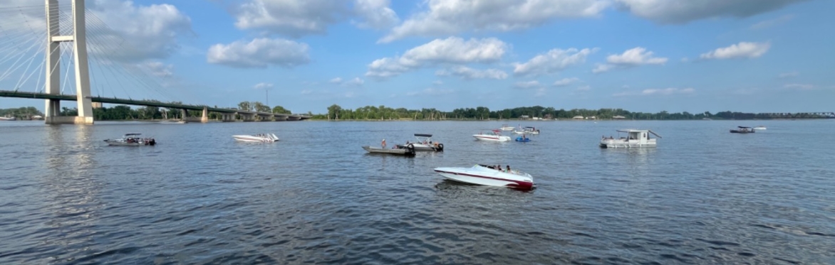 A picture of boats on a river with a bridge in the background