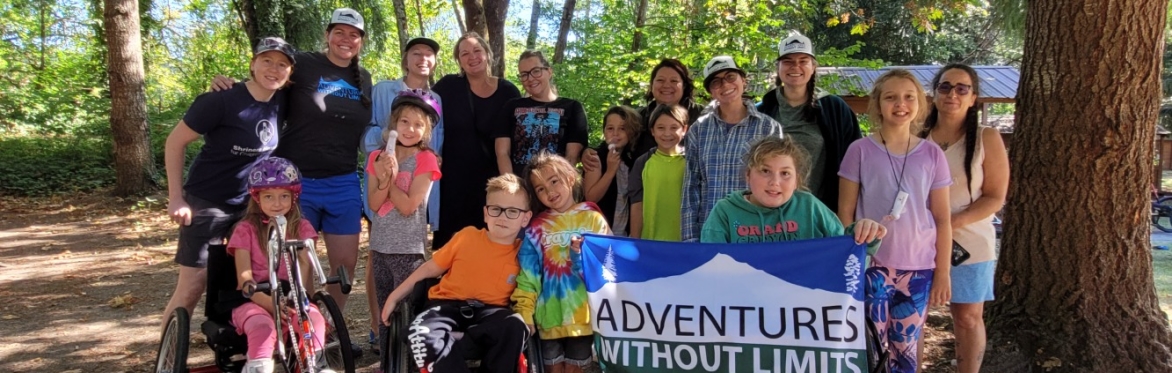 A group gathers after a camping trip, holding an AWL flag