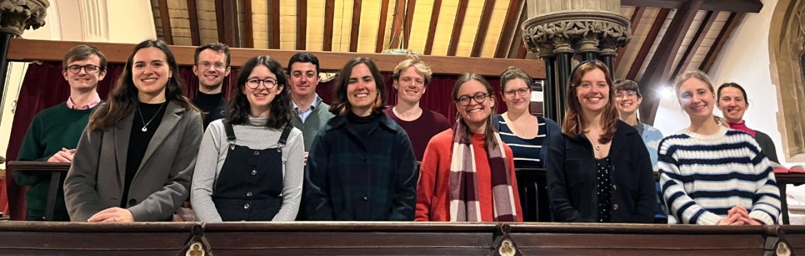 A group of young singers standing in the choir stalls of a church