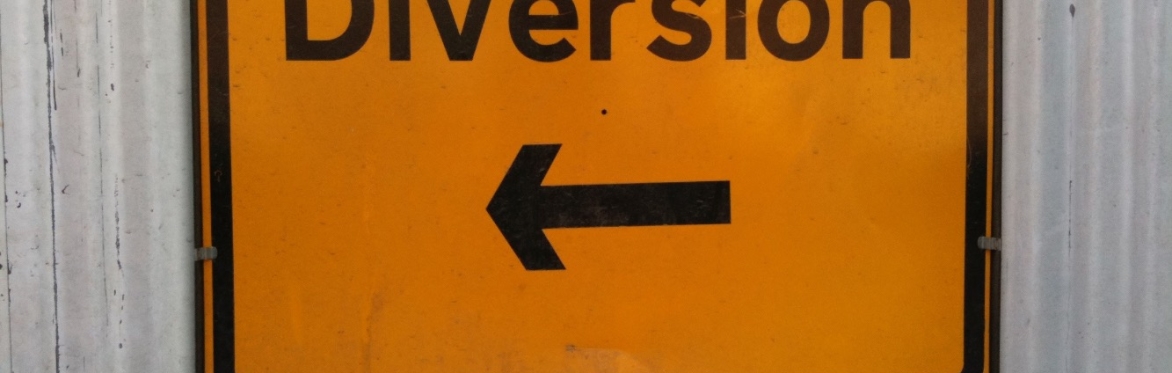 Diversion sign against a wall with Joy graffitied at the top