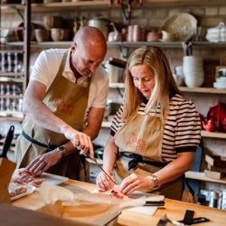 Two people preparing food in a cookery school