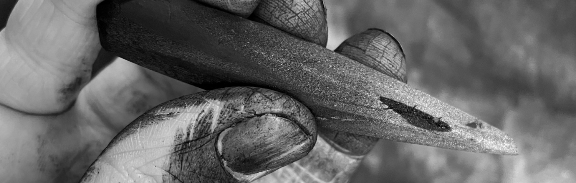 a hand holding a stick of charcoal