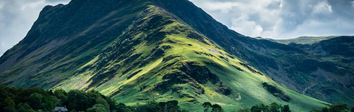 A photograph of a hill and lake in the Lake District