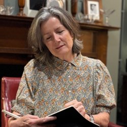 Author Judith Heneghan sat in the Cabinet Rooms Foreign Office writing in a pad that’s resting on her knee