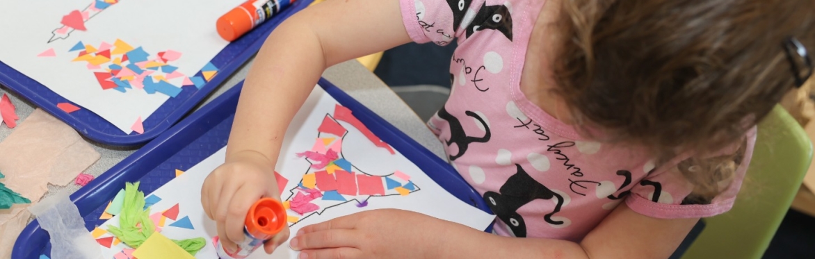 A young girl doing a craft project.