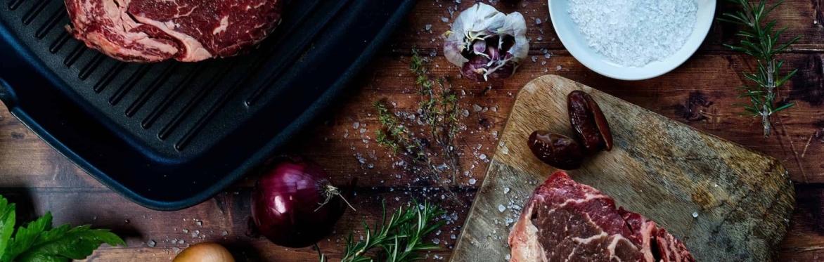 Joints of meat displayed with herbs and garlic