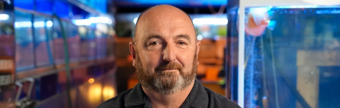 Phil Wanless sitting in his aquatics shop