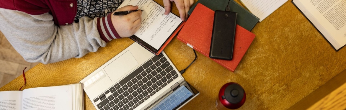 student studying with laptop and notepad