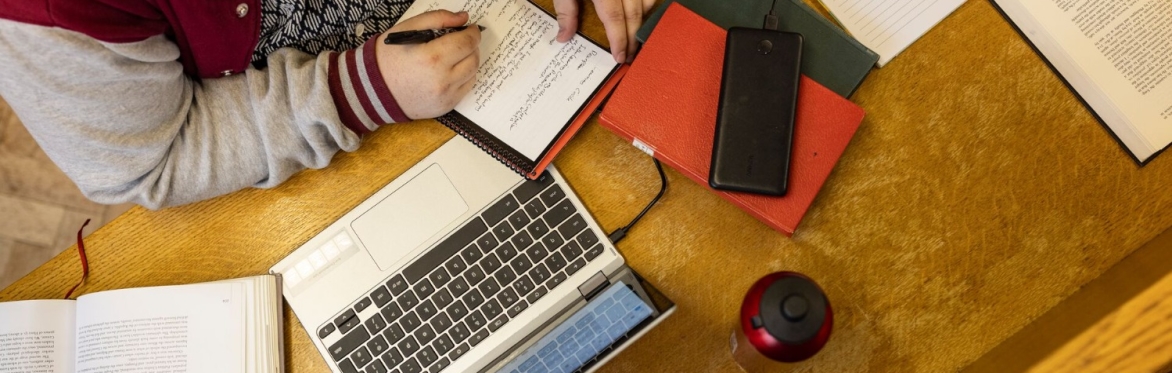 student studying with laptop and notepad