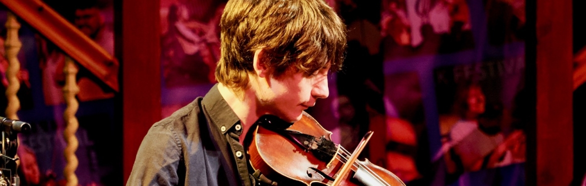 Ryan young side on playing fiddle onstage