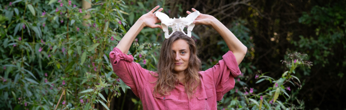 A woman holding pelvic bones like a crown, looking into the camera.