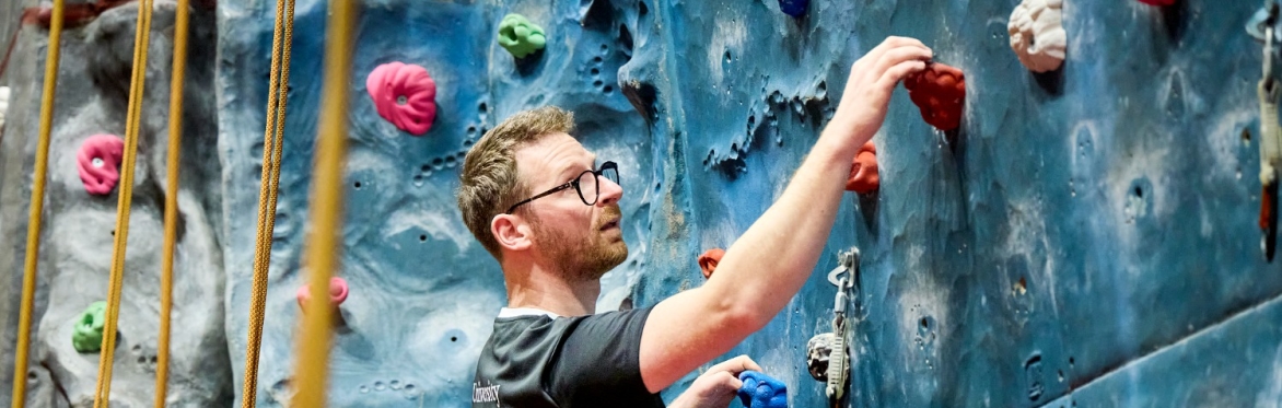 Participants bouldering on the climbing wall as part of an Active Campus session