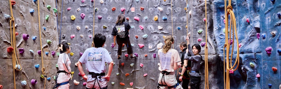 Participants climbing on a climbing wall as part of an Active Campus session