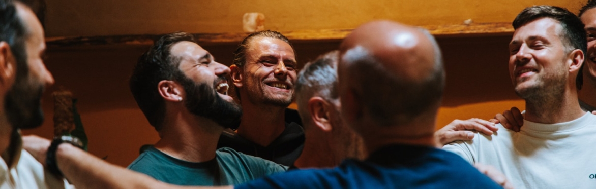 Een groep mannen die lachen en met elkaar in verbinding staan