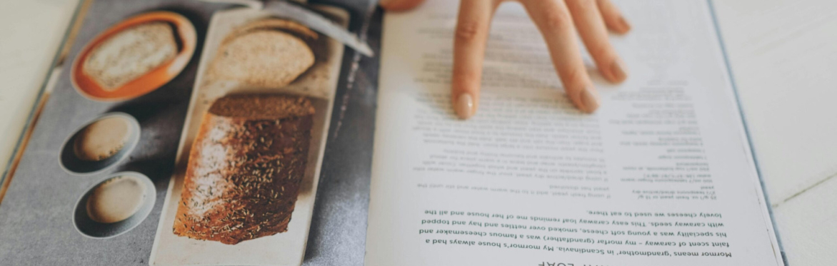 recipe book being held open and browsed by hand