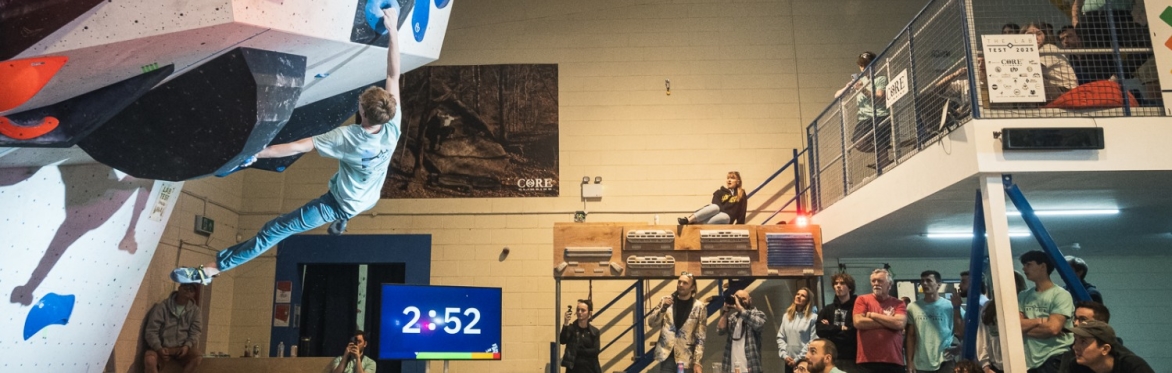 competitor climbing at the climbing lab competition with the crowd cheering