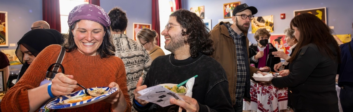 Two guests smiling and eating at 2025's A Taste of Nations in MSA's main hall