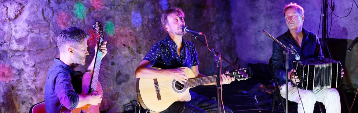 Photo of the band (3 men) playing instruments