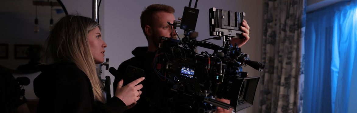 two people holding a camera