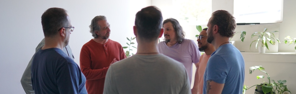 A group of men standing in a circle talking