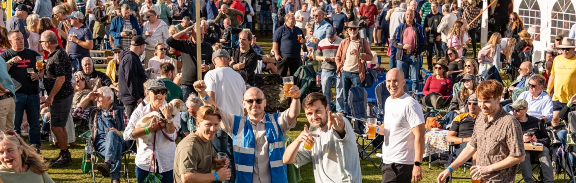 people at an outdoor festival drinking and dancing in the sun