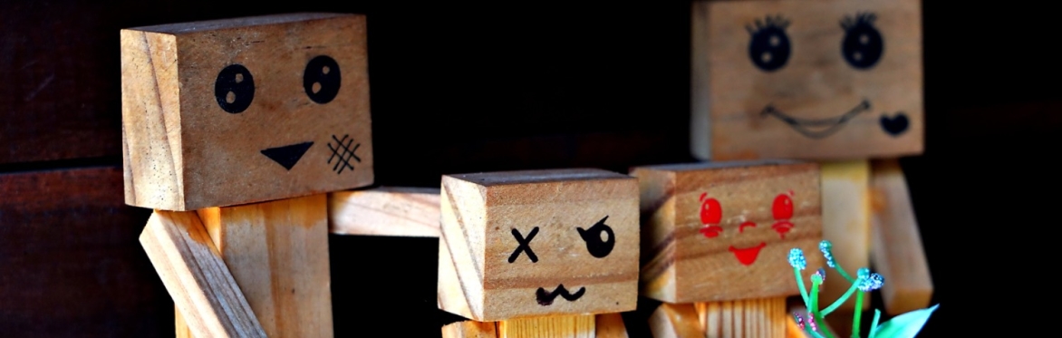 A wooden block family of four with emotions painted on their faces