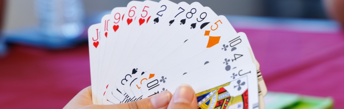 Two hands holding a spread of playing cards.