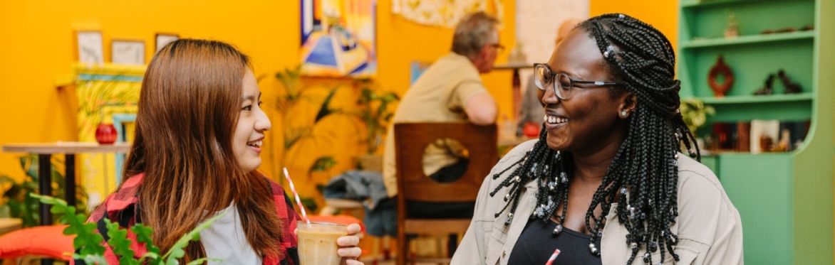 Two people at a café with coffee and cake