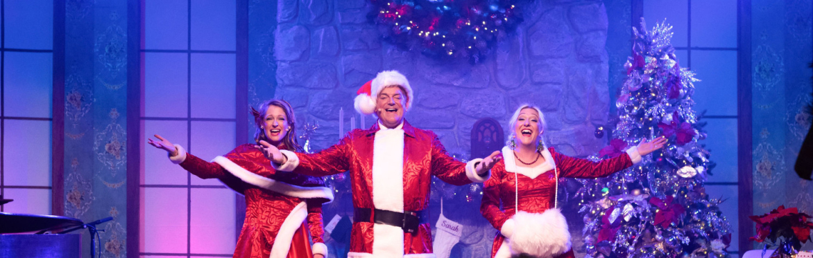 3 singers on stage in Christmas costumes