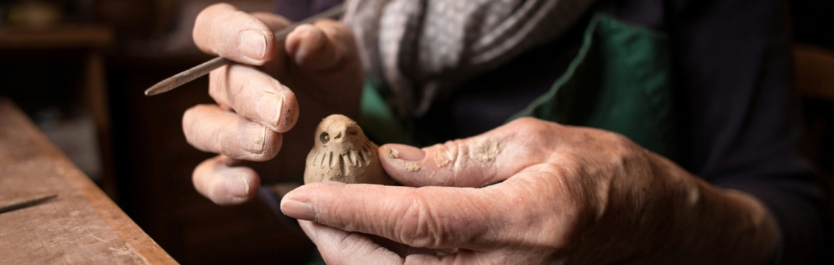 Hands holding a clay model of a bird