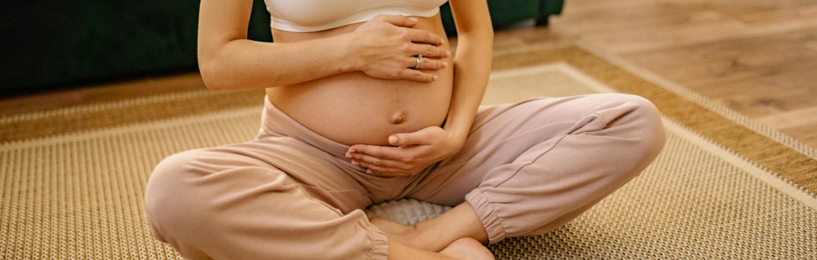 Woman holding baby bump while relaxing