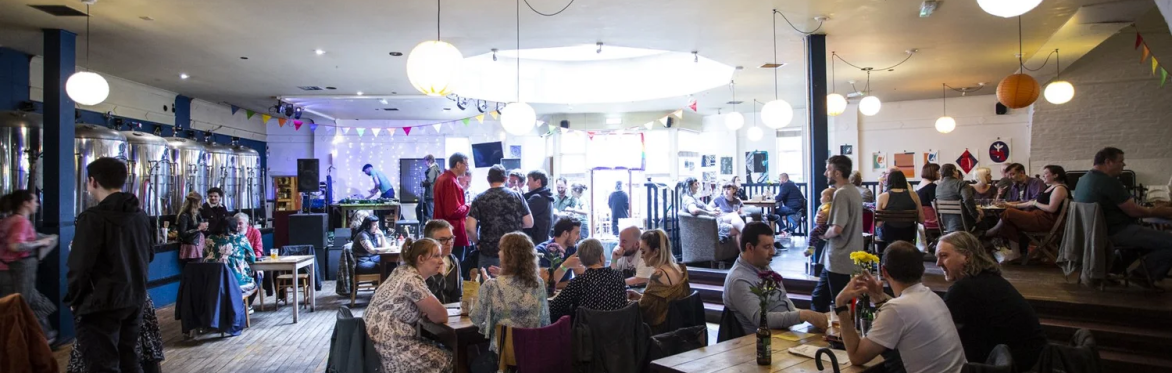 Interior of the cafe space with people sitting around tables