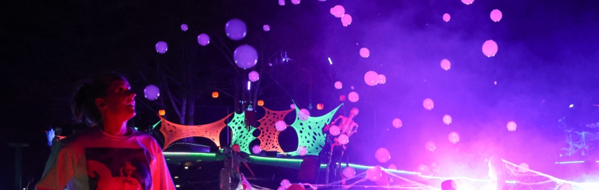 Woman looks at fog bubbles under black lights.