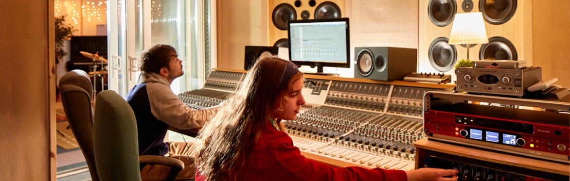 Two students in the recording studio at a mixing desk