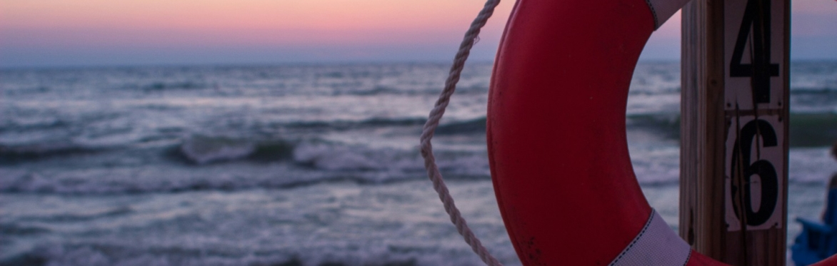 A lifebouy with sunset over the sea in background