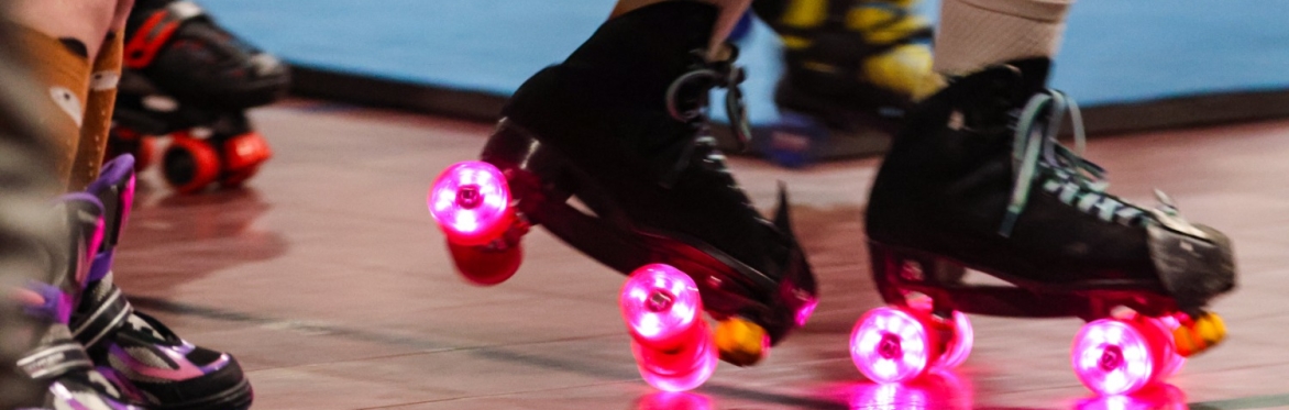 Two friends hold hands while skating