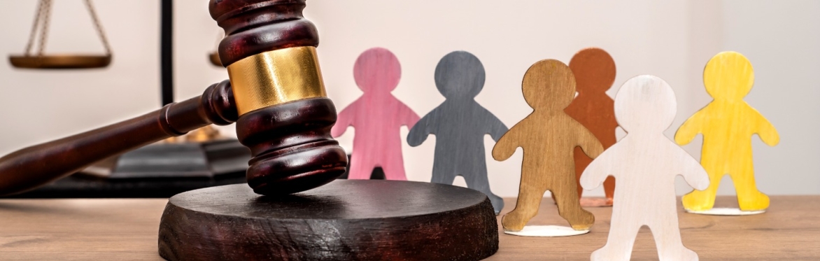 A gavel with colourful wooden figures beside it.
