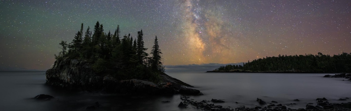 A tree-covered island under the Milky Way