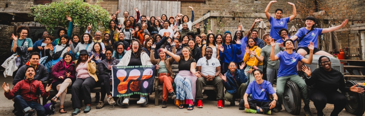 Image of a crowd of people of colour in front of a barn