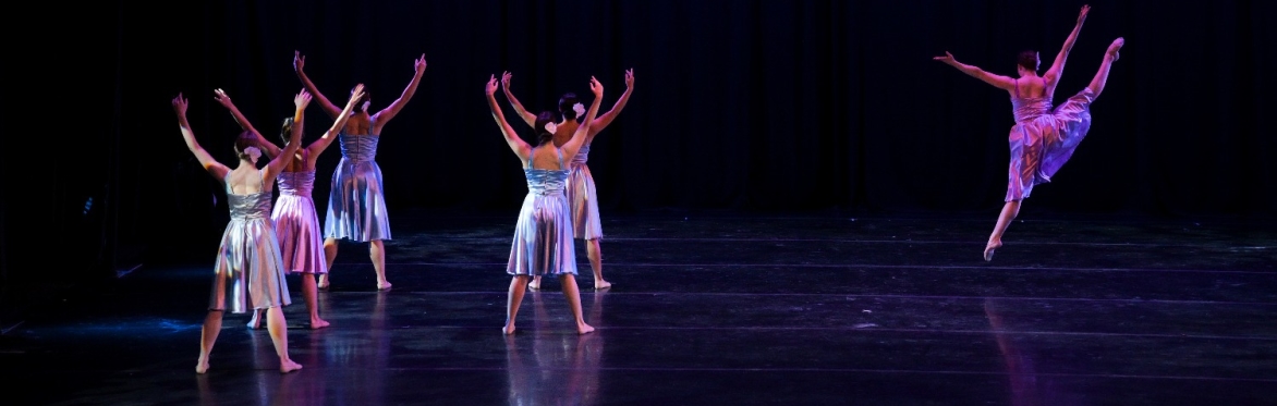 Dancers leap about the stage.