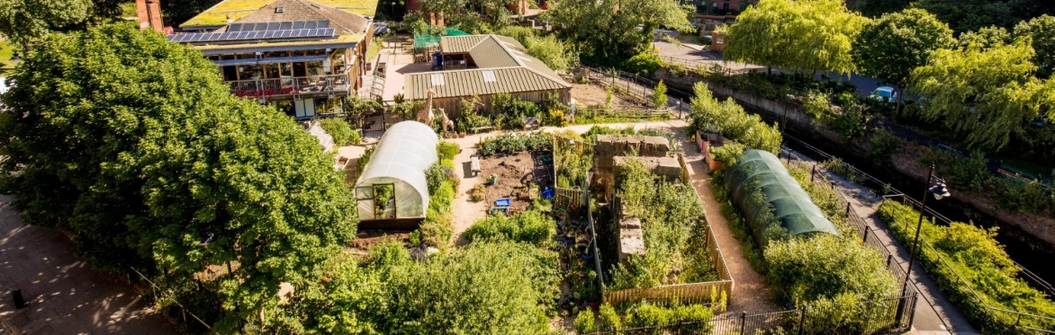 An aerial picture of the farm, showing the farm building, the barn, and gardens from above