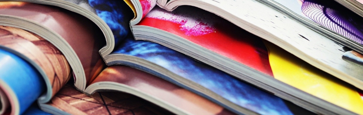 Colourful magazines stacked up, each one laying open