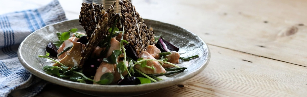 Dinner table set with a Scandi inspired meal of crispbreads and salmon with mixed leaves