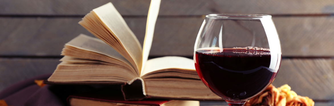 Open books and a glass of red wine