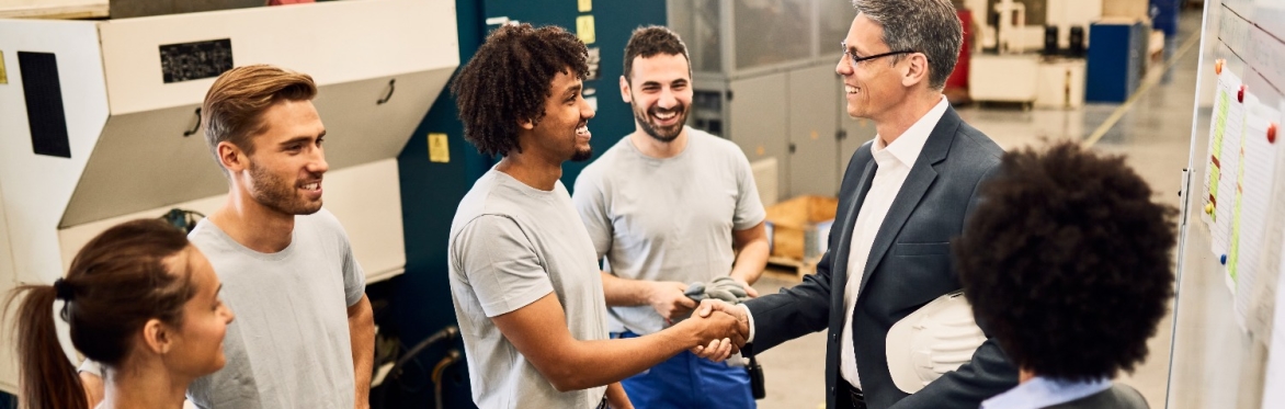 A goup of workers being congratulated by a manager.